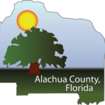 seal for Alachua County Florida in shape of county map outline with sun and large tree