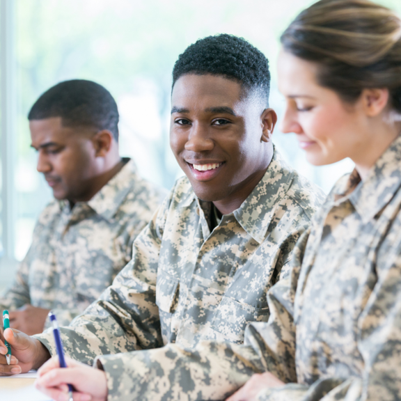 military academy three military personnel in classroom taking notes